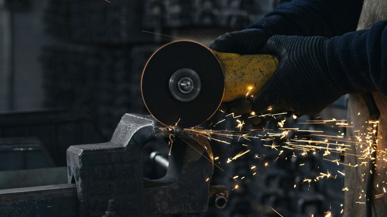 Angle grinder cutting steel held in a bench vice